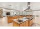 Gourmet kitchen with a center island, stainless steel range hood, and wood cabinetry at 1383 Opal Valley St, Henderson, NV 89052