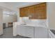 Well-lit kitchen featuring white appliances, white countertop, wood cabinets, and gray tile flooring at 1720 Eastwood Dr, Las Vegas, NV 89104