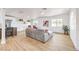 Open-concept living room with a gray couch, wood-look floors, and bright white walls at 1731 Sherwin Ln, Las Vegas, NV 89156