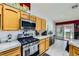 Features a modern gas range, tile counters, and wood cabinets in this kitchen at 1905 Dakota Hills Ave, Las Vegas, NV 89123