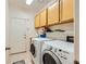Well-lit laundry room with tile flooring, built-in cabinets, shelving and modern appliances at 1905 Dakota Hills Ave, Las Vegas, NV 89123