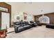 Open-concept living room showcases a leather sofa, chair, window shutters, and neutral flooring at 1905 Dakota Hills Ave, Las Vegas, NV 89123