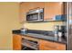 Modern kitchen featuring wooden cabinetry, stainless steel appliances, and black granite countertops at 2000 N Fashion Show Dr # 5326, Las Vegas, NV 89109