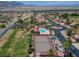Aerial view of homes featuring a pool, tennis court, and mature palm trees at 2505 Links Dr, Laughlin, NV 89029