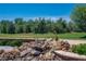 Scenic backyard features a rock waterfall, lush greenery, and a view of the greenbelt at 2505 Links Dr, Laughlin, NV 89029