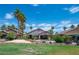 Beautiful backyard with mature palms and landscaping, rock waterfall, and covered patio at 2505 Links Dr, Laughlin, NV 89029