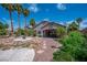 A serene backyard with palm trees, rock features and a covered patio at 2505 Links Dr, Laughlin, NV 89029
