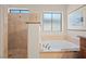 A bright bathroom shows a walk-in shower and soaking tub under a double window at 2505 Links Dr, Laughlin, NV 89029