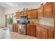 Well-lit kitchen boasts wood cabinets, stainless steel appliances, and sliding door access to the backyard at 2505 Links Dr, Laughlin, NV 89029