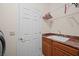 Laundry room with cherry wood cabinets, utility sink, and door to outside at 2505 Links Dr, Laughlin, NV 89029