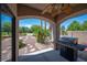 Covered patio with outdoor grill overlooking the backyard with rock landscaping at 2505 Links Dr, Laughlin, NV 89029