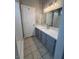 Bright bathroom features gray cabinetry, neutral countertops and large mirror at 2694 Hillgrass Rd, Las Vegas, NV 89123