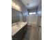 Bathroom featuring a modern vanity, white tiled tub, and neutral colors at 2694 Hillgrass Rd, Las Vegas, NV 89123
