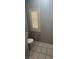 Toilet in bathroom with white walls, tile floor, and window with shutter at 2694 Hillgrass Rd, Las Vegas, NV 89123