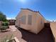Back exterior view of home featuring stucco siding, windows with sunshades, patio, and low maintenance backyard at 2694 Hillgrass Rd, Las Vegas, NV 89123