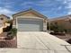 Two-car garage with concrete driveway and low maintenance landscaping at 2694 Hillgrass Rd, Las Vegas, NV 89123