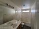 Neutral bathroom featuring a white tub and shower, white tiling, and an expansive vanity with a mirror at 2711 Morning Break Ct, Las Vegas, NV 89142