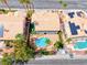 Aerial view of a private backyard with a sparkling pool and lush landscaping, nestled between neighboring homes with terracotta roofs at 2741 Chokecherry Ave, Henderson, NV 89074