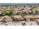 Bird's-eye view of a residential area featuring terracotta-roofed homes, lush trees, and well-maintained lawns in a suburban setting at 2741 Chokecherry Ave, Henderson, NV 89074