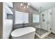 Modern bathroom features a soaking tub, glass-enclosed shower, and updated fixtures at 2741 Chokecherry Ave, Henderson, NV 89074