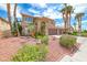 Inviting two-story home with a three-car garage showcases lush desert landscaping and mature palm trees in a well-maintained yard at 2741 Chokecherry Ave, Henderson, NV 89074