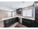 Modern kitchen features black cabinetry, mosaic backsplash, and stainless steel dishwasher at 2741 Chokecherry Ave, Henderson, NV 89074