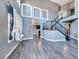 Bright and airy living room with hardwood floors, staircase, and modern hanging light fixture at 2741 Chokecherry Ave, Henderson, NV 89074