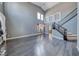 Spacious living room features modern gray walls, hardwood floors, abundant natural light, and a staircase with elegant railing at 2741 Chokecherry Ave, Henderson, NV 89074