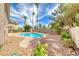 Backyard view of a kidney-shaped pool with palm trees, rock landscaping and concrete patio at 2741 Chokecherry Ave, Henderson, NV 89074