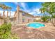Backyard swimming pool with rock surround, gravel landscaping and palm trees at 2741 Chokecherry Ave, Henderson, NV 89074