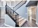 Elegant staircase with black railing and neutral carpet at 2741 Chokecherry Ave, Henderson, NV 89074