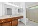 Bright bathroom features a wood vanity with double mirrors and a glass shower-tub combination at 2836 Linkview Dr, Las Vegas, NV 89134