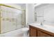 Bathroom with a wood vanity, large mirror, and a shower-tub combination with gold trim at 2836 Linkview Dr, Las Vegas, NV 89134