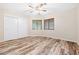 This bedroom features a sliding door closet, wood-look floors, two windows, and a ceiling fan at 2836 Linkview Dr, Las Vegas, NV 89134