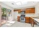 Functional kitchen with stainless steel appliances, wooden cabinets, and sliding glass doors leading to the patio at 2836 Linkview Dr, Las Vegas, NV 89134