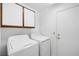 A white washer and dryer sit beneath white cabinets in the laundry room at 2836 Linkview Dr, Las Vegas, NV 89134