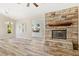 Open living room with a cozy stone fireplace, natural light, and seamless flow to the outdoor area at 2836 Linkview Dr, Las Vegas, NV 89134