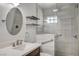 Bright bathroom featuring a glass shower, a modern vanity with a round mirror, and floating shelves at 3143 El Chico Ct, Las Vegas, NV 89120