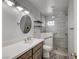 Bright bathroom featuring a glass shower, a modern vanity with a round mirror, and floating shelves at 3143 El Chico Ct, Las Vegas, NV 89120