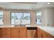 Bright kitchen featuring stainless steel dishwasher, double sink, and ample light from multiple windows at 3143 El Chico Ct, Las Vegas, NV 89120