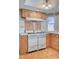 Galley kitchen features tile countertops, white appliances, and wood flooring at 3143 El Chico Ct, Las Vegas, NV 89120