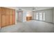 Bright living room with gray carpet, storage cabinets, and double glass doors to outdoor area at 3143 El Chico Ct, Las Vegas, NV 89120