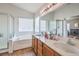 Bright bathroom featuring double sinks, a large soaking tub, and a separate glass-enclosed shower at 3440 Meridale Dr, Las Vegas, NV 89117