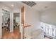 Second floor hallway featuring hardwood floors, white staircase and access to bedrooms at 3440 Meridale Dr, Las Vegas, NV 89117