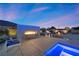 Backyard featuring outdoor seating area, modern fireplace, and ambient lighting at 4050 N Tomsik St, Las Vegas, NV 89129