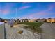 Expansive backyard with manicured lawn, gravel pathways, desert plants, and thoughtful landscaping details at 4050 N Tomsik St, Las Vegas, NV 89129