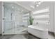 Bright bathroom showcasing a glass-enclosed shower, freestanding tub, and contemporary lighting at 4050 N Tomsik St, Las Vegas, NV 89129