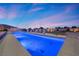 Long pool featuring lit stair access surrounded by desert landscaping at dusk at 4050 N Tomsik St, Las Vegas, NV 89129