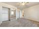 Bedroom with neutral carpet, ceiling fan, and mirrored closet doors enhancing the room's visual space at 480 China St, Pahrump, NV 89048