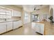 Bright kitchen features white cabinets, tile flooring, and sliding door to outdoor space at 480 China St, Pahrump, NV 89048